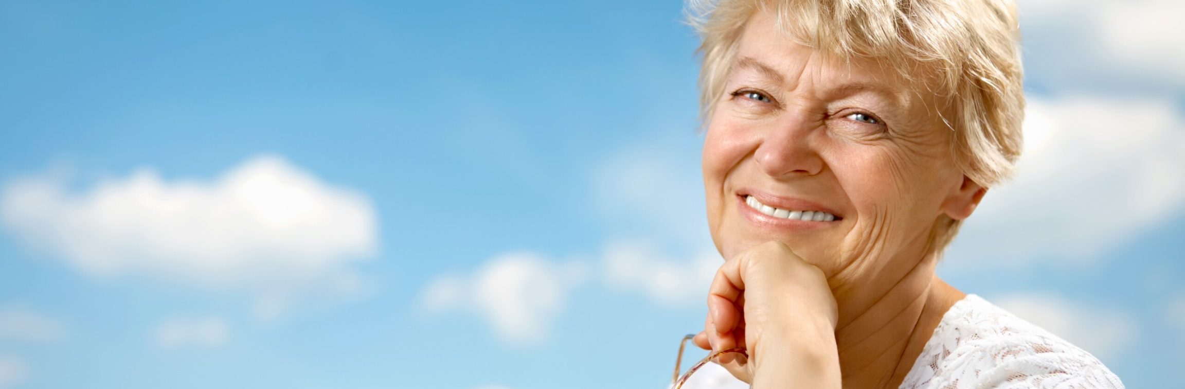 The beautiful woman is elderly against the bright blue sky